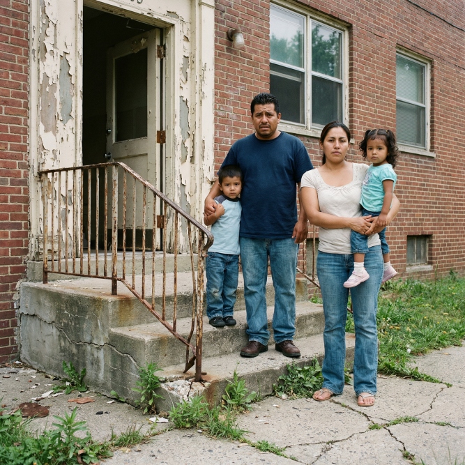 Family Outside Neglected Building